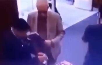 Momento en que un guardia de la librería procede a verificar los objetos que llevaba el embajador. Pagó por otros productos, pero no por un libro.