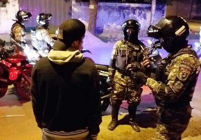 Un efectivo del Grupo Lince verifica la cédula de identidad de un poblador del Bañado Sur, junto con sus compañeros.