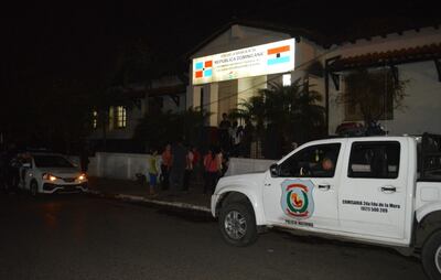 Móviles policiales resguardan la entrada a la escuela “República Dominicana” durante el cateo.