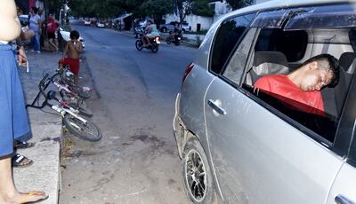 Un acompañante está dormido dentro del coche del agente. A la izq., la bicicleta del chico.