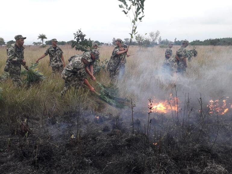 Los militares tratan de sofocar las llamas, pero no cuentan con equipamiento adecuado.