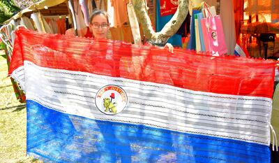 Luz Martínez exhibe una hermosa bandera paraguaya de ao po’i con encaje ju. El precio del artículo es G. 500.000.