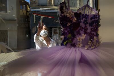 La gerente de un comercio de accesorios de danza limpia uan vitrina en Mulhouse, Francia.