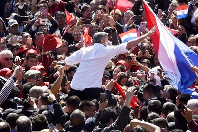 El presidente Mario Abdo Benítez recibe una bandera paraguaya ayer durante el acto en su respaldo realizado en la Plaza de la Democracia.