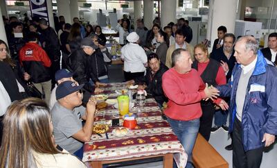 El intendente Mario Ferreiro saluda a uno de los clientes en las nuevas instalaciones del comedor del Mercado 4. Las cocineras se mostraron muy agradecidas y le regalaron un ramo de flores.