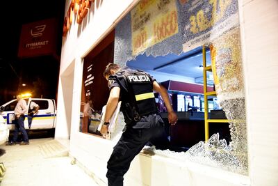 Un efectivo de la Policía ingresa al interior de Citymarket de Choferes del Chaco y Alfredo Seiferheld, a través del ventanal cuyo vidrio rompieron a golpes los criminales para perpetrar el intrépido robo en la madrugada de ayer.