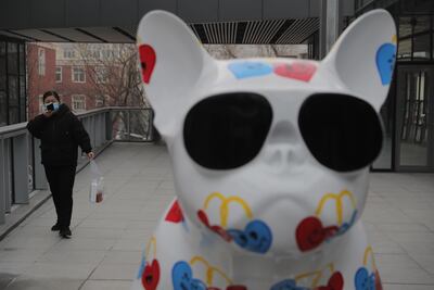 Una mujer, con máscara de protección, camina por las calles de Pekín, China.
