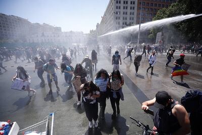 Fuerzas Especiales de Carabineros dispersan a manifestantes que protestan durante una nueva jornada de movilizaciones en contra del Gobierno en todo el país, este lunes frente al Palacio de La Moneda en Santiago (Chile).