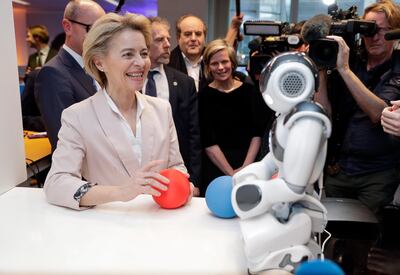 La presidenta de la Comisión Europea, Ursula von der Leyen, junto a un robot durante su visita al Centro Xperience de Inteligencia Artificial, este martes en Bélgica (Bruselas).
