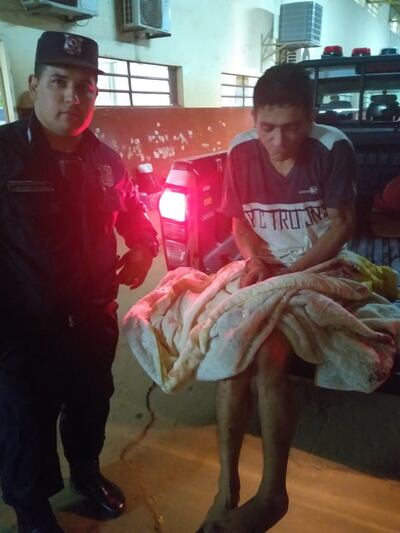 El delincuente capturado aparece junto a un agente del orden.