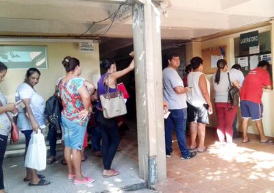 Pacientes y familiares hacen fila para retirar resultados de dengue en el hospital de Trinidad.