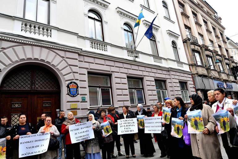 Mujeres de Srebrenica y miembros bosnios de la Asociación de sobrevivientes de la Guerra en Bosnia (1992 - 1995), portan pancartas frente a la embajada de Suecia en Sarajevo. Protestan contra el otorgamiento del Premio Nobel de Literatura al escritor Peter Handke.