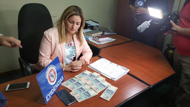La Fiscal Fatima Capurro durante la entrevista que brindó a los medios de prensa. También se observa el dinero recuperado.