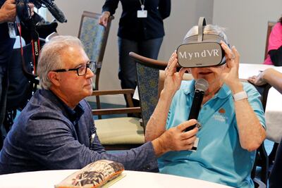 El director de salud de John Knox Village, Mark Rayner pregunta a una anciana sobre su experiencia con las gafas de realidad virtual de MyndVR.