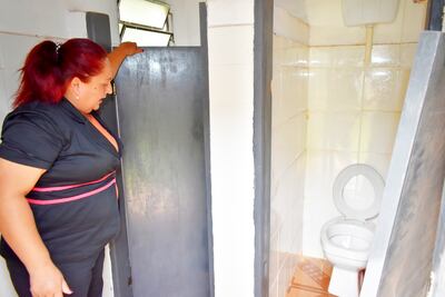 La edil Lourdes Aguirre muestra el sanitario que figura como terminado en la escuela Bernardino Caballero.