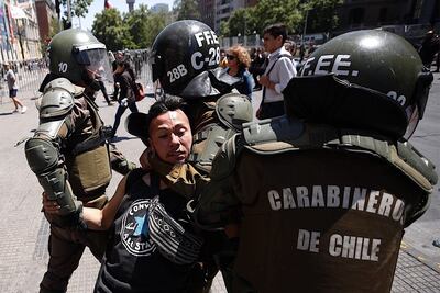 Fuerzas Especiales de Carabineros detienen a un manifestante durante una nueva jornada de movilizaciones en contra del Gobierno en todo el país, este lunes frente al Palacio de La Moneda en Santiago (Chile).