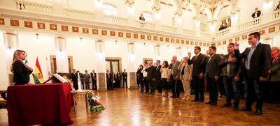 La presidenta interina de Bolivia, Jeanine Áñez (i), tomando juramento al gabinete de su gobierno provisional, cuya principal tarea es administrar la transición hasta las próximas elecciones.