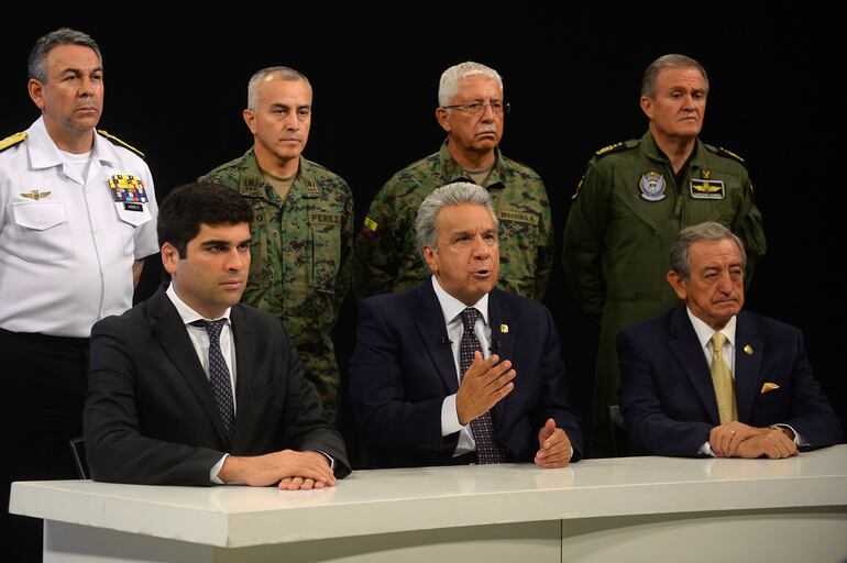 El presidente de Ecuador, Lenin Moreno (C) habla en radio y televisión en Guayaquil, Ecuador, junto con su vicepresidente Otto Sonnenholzner (izquierda), el ministro de Defensa Nacional Oswaldo Jarrin (derecha) y el alto mando militar.