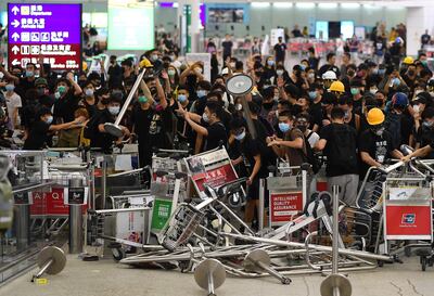Manifestantes prodemocracia bloquean la entrada a las terminales del aeropuerto de Hong Kong.