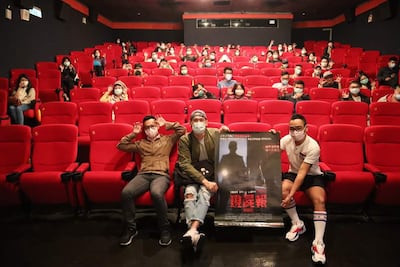Asistentes a una de las funciones de "Morgue" sostienen el afiche internacional de la película en Taiwán.