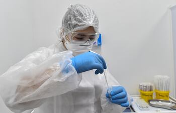 Una investigadora de un laboratorio en Moscú, Rusia, realiza una prueba con una muestra de saliva contaminada con COVID-19.