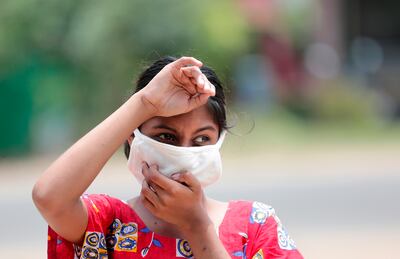 Una niña usa una mascarilla protectora mientras hace las labores diarias en India.