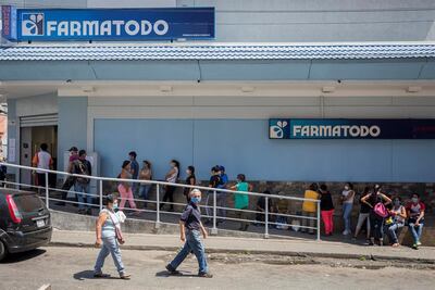 Decenas de personas hacen fila este miércoles para abastecerse de medicamentos y productos de higiene personal en una farmacia de Caracas (Venezuela).