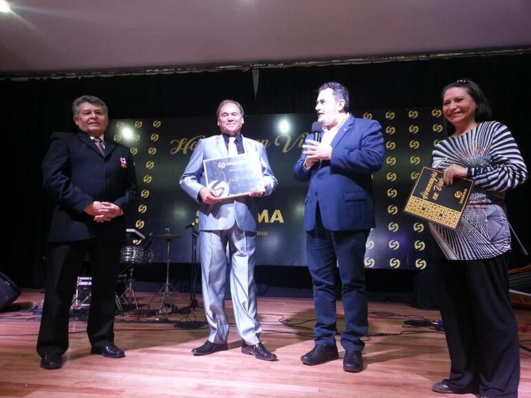 Emocionado, Rito Pedersen recibió la plaqueta de reconocimiento de manos de Elzear Salemma. Lo acompañan Lucio Ruíz Díaz y Marlene Sosa Lugo.