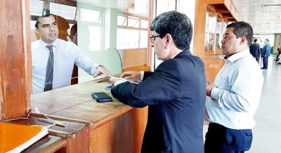 El actuario judicial Marcelo Bogado recibe el escrito del abogado Alcides Cáceres (de traje). Fue ayer en tribunales.