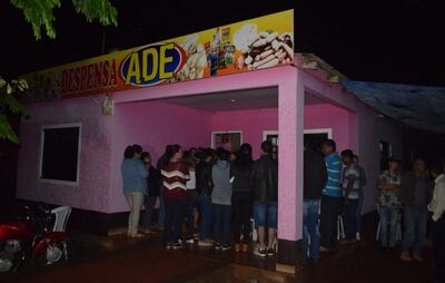 Vecinos de Vaquería se congregan frente a la casa de los infortunados a la espera de los resultados de la pesquisa.