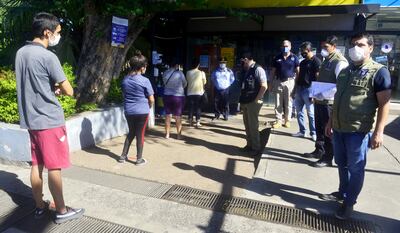 El fiscal Eugenio Ocampos verifica que los clientes guarden la debida distancia en el supermercado Stock.