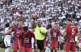 Mientras Camacho en el piso tras recibir el mordisco de Amorebieta (5), el árbitro Aquino exhibe la roja que alcanzó a ambos.