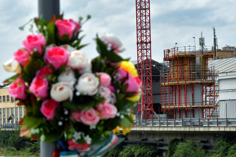 Un ramo de flores homenajea a las víctimas cerca del sitio donde se construye el nuevo puente.