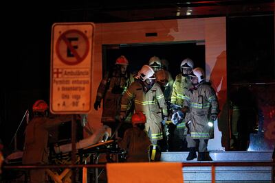 Los bomberos trasladan a un paciente durante un incendio en el Hospital privado Badim en el barrio de Tijuca, Río de Janeiro, Brasil