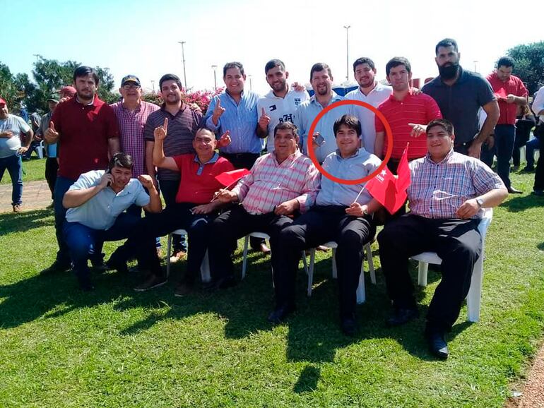 Eduardo Jara portando una banderita de la ANR, a su derecha su secretario privado.