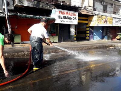 Operarios limpian la Avda. Rodríguez de Francia en zona del Mercado 4. “La manguereada” es tradición cada 1 de enero.