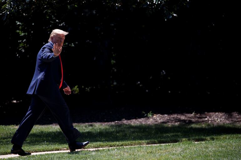 El presidente Donald Trump saluda a la prensa en el jardín de la Casa Blanca.