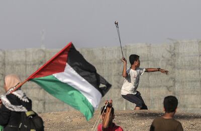 Un manifestante palestino lanza una piedra hacia soldados israelíes durante un enfrentamiento en la Franja de Gaza.