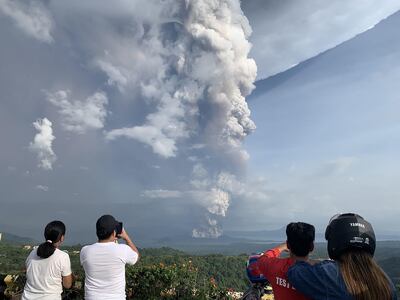 Varias personas observan una erupción del volcán Taal desde el pueblo de Tagaytay, en la provincia filipina de Cavite.