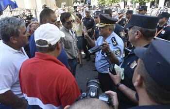 Policías conversan con los líderes sindicales de la ANDE y de otras instituciones públicas frente a la sede del Ministerio de Hacienda en la mañana de este lunes.