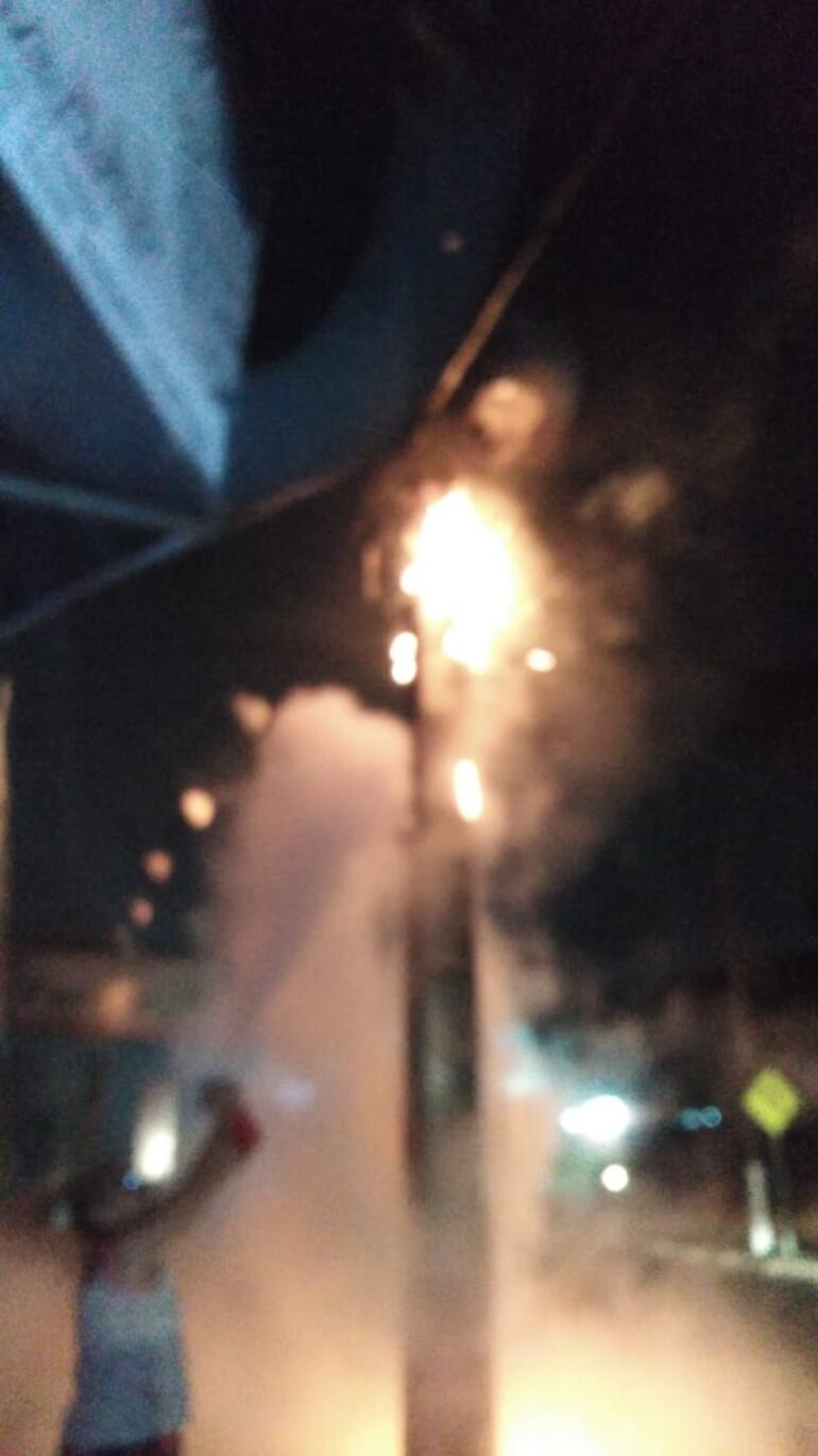 Una mujer del barrio San Miguel intenta apagar el incendio generado tras la explosión de un transformador de ANDE.