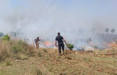 Vecinos y policías tratan de sofocar las llamas en el barrio Santa Lucía de Villarrica.
