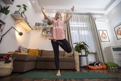 La instructora de yoga húngara da una clase en línea para sus alumnos desde su casa.