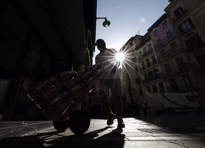 Dos trabajadores suministran bebida a un bar de la calle Estafeta de Pamplona, en España.
