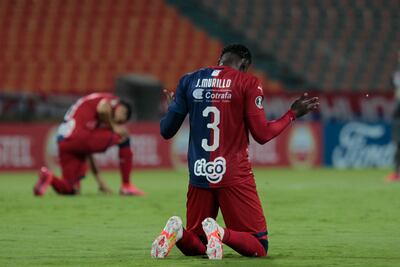 Colombia's Atletico de Medellin players observe a minute of silence in honor of the victims of COVID-19, during their closed-door Copa Libertadores group phase football match against Venezuela's Caracas at the Atanasio Girardot Stadium in Medellin, Colombia, on September 16, 2020, amid the COVID-19 novel coronavirus pandemic. (Photo by Fredy BUILES / POOL / AFP)
