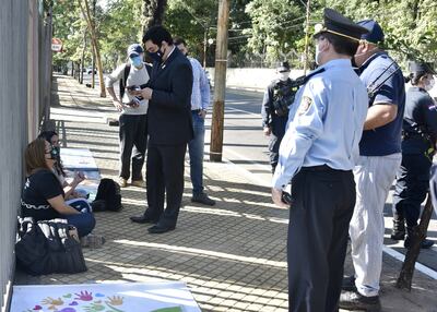 El viceministro Eduardo Escobar dialoga con dos manifestantes encadenadas frente a Mburuvicha Róga, sobre la avenida Mariscal López.