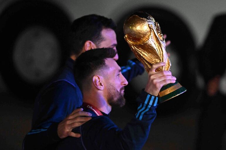 Lionel Messi y Lionel Scaloni al salir del avión para saludar la multitud con la Copa del Mundo en mano. 