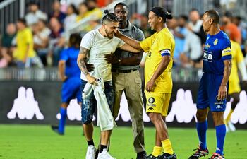 Un aficionado ingresó al campo para saludar a su ídolo Ronaldinho Gaúcho. Observa Cafú, capitán del equipo comandado por Roberto Carlos.