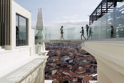 Varias personas cruzan la pasarela de cristal de la azotea del nuevo Hotel Riu, ubicado en el Edificio España, de Madrid que se ha convertido a los pocos días de su inauguración en uno de los nuevos atractivos de la capital.