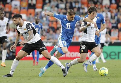Los defensas del Valencia, Jesús Vázuquez (d) y el paraguayo Omar Alderete (i), disputan el balón ante Joaquín Sánchez (c), centrocampista del Betis, durante el encuentro de la jornada 36 entre el Valencia CF y el Real Betis, este martes en el estadio de Mestalla en Valencia.